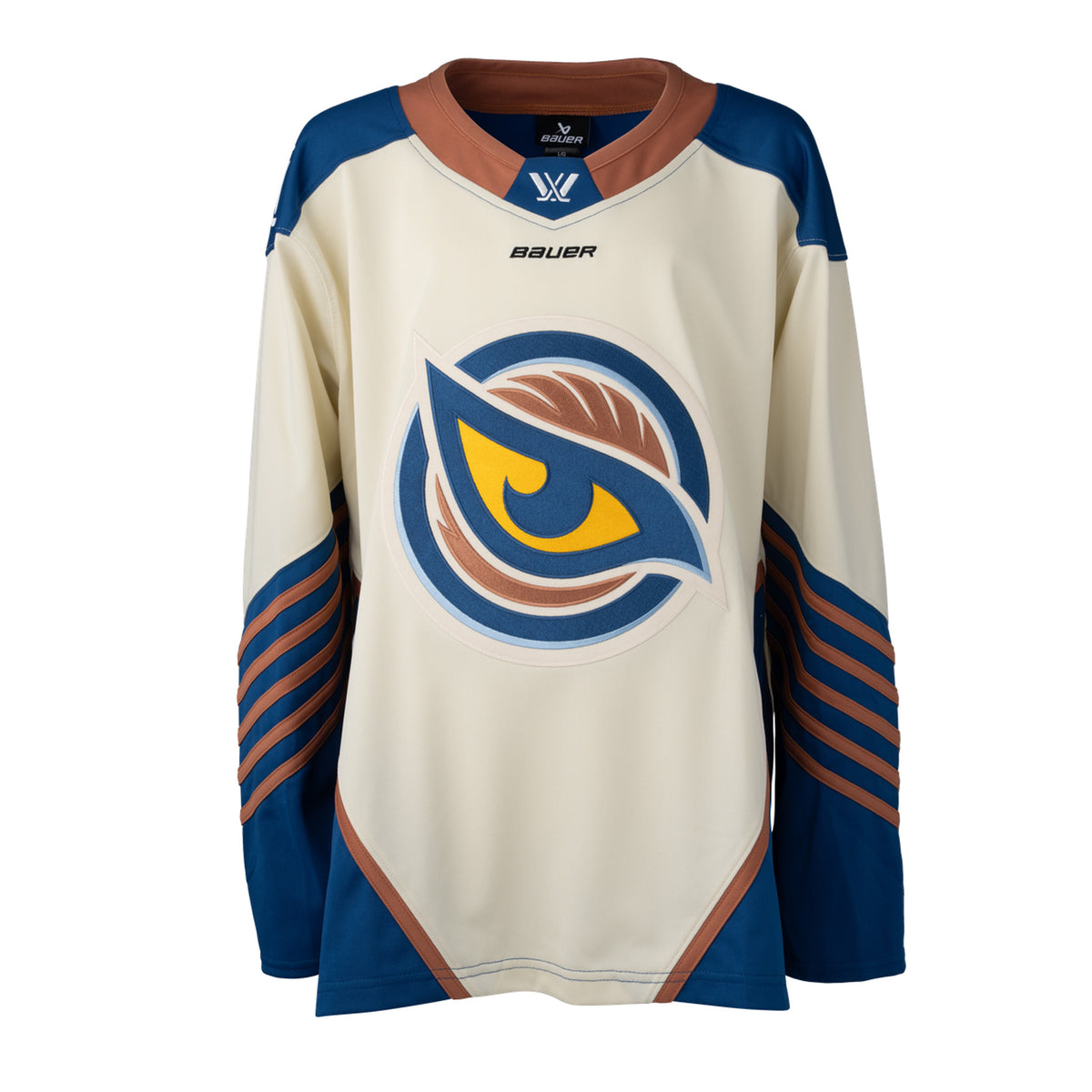Front of a cream-colored jersey with the Vancouver Goldeneyes logo in the center. The hips have blue color blocking with a tan line on top. The tan collar has a blue color block with the PWHL logo and the Bauer logo is beneath it. The blue shoulder caps have the PWHL logo on the left shoulder. The sleeves are cream and from the elbow down are blue with small tan stripes.
