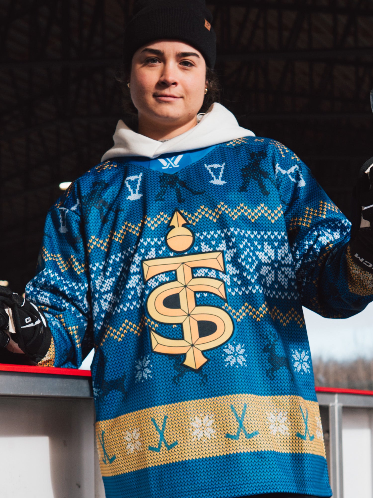 Person wearing a blue sweater with a logo