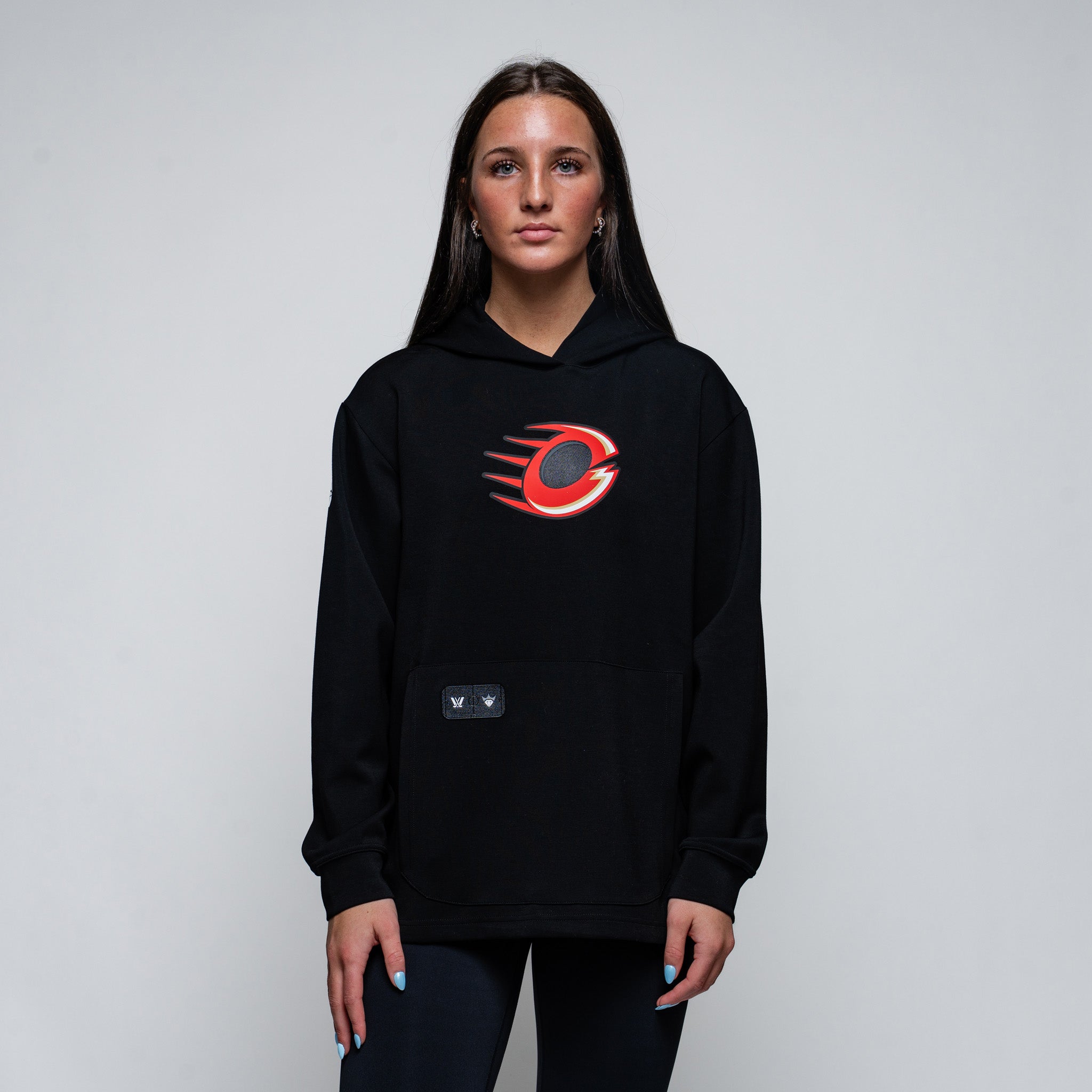 Person wearing a black hoodie with a red and white logo on a gray background