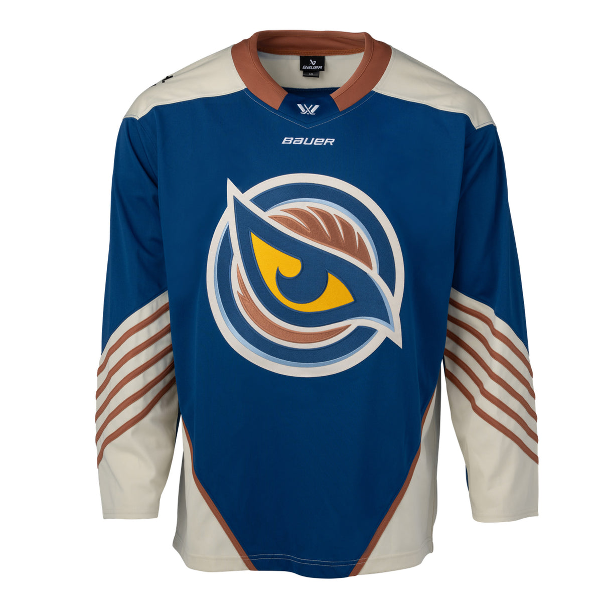 Front of a blue jersey with the Vancouver Goldeneyes logo in the center. The hips have cream color blocking with a tan line on top. The tan collar has a blue color block with the PWHL logo and the Bauer logo is beneath it. The cream shoulder caps have the PWHL logo on the left shoulder. From the elbow down is cream with small tan stripes. 