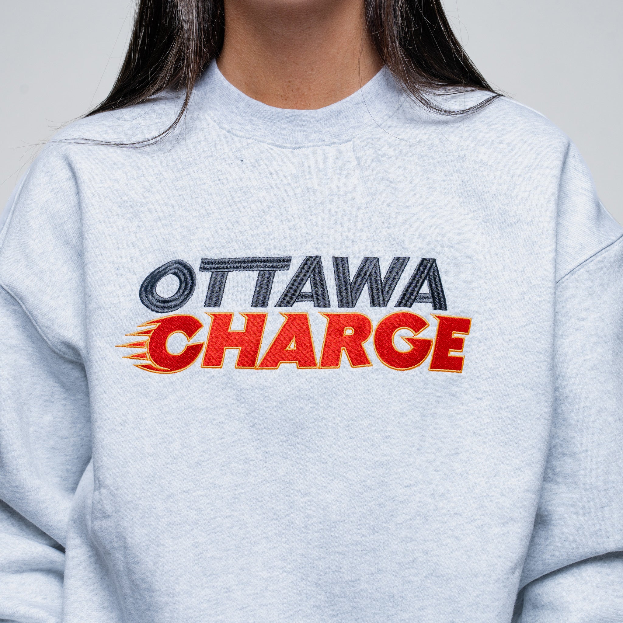 Gray sweatshirt with 'Ottawa Charge' text on a plain background